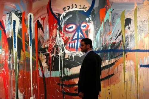佳士得纽约战后及当代艺术部门主席Loic Gouzer站在让·米切尔·巴斯奎亚的《无题》旁。图片：致谢KENABETANCUR/AFP/Getty Images