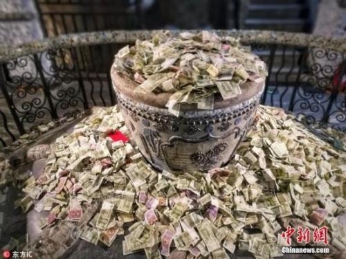 资料图：天津一著名景点内，参观的游客纷纷向景点内的各处投撒钱币，掷币祈福。由于数量较多，堆积起来的钱币甚是显眼，成了独特的“风景”。 图片来源：东方IC 版权作品 请勿转载