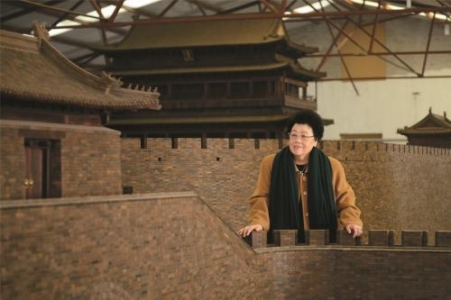 陈丽华女士和她心爱的“老北京城门”。中国紫檀博物馆供图