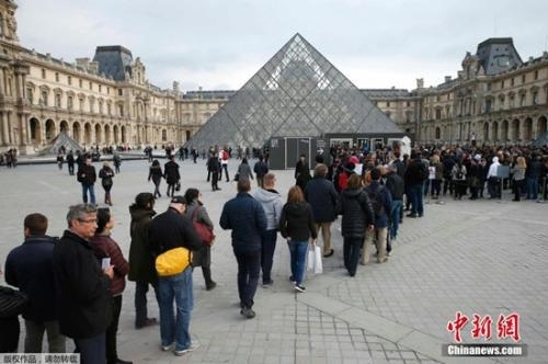 游客在法国巴黎的卢浮宫前排队等待参观。