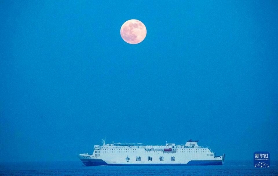 12月19日在山东省烟台市蓬莱区海滨拍摄的满月。